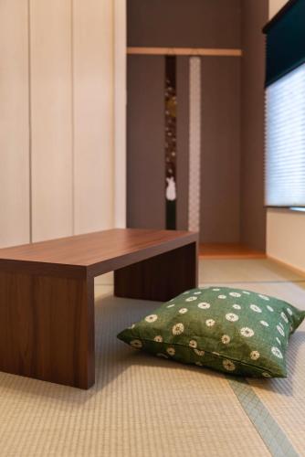 a wooden table and a pillow in a room at Tino Mizuki in Osaka