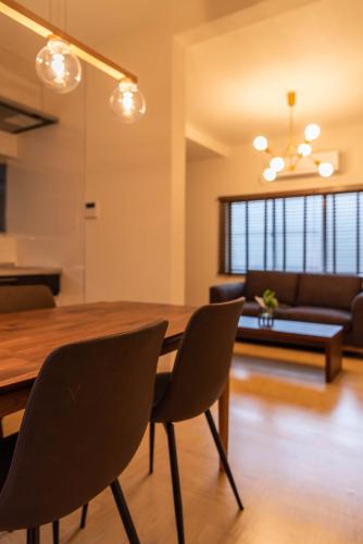 a dining room with a wooden table and chairs at Tino Mizuki in Osaka