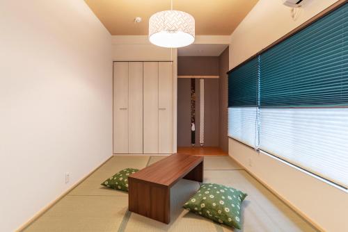 a living room with a bench and pillows at Tino Mizuki in Osaka