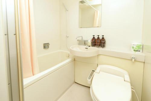 a white bathroom with a toilet and a sink at Castle Inn Komaki in Komaki