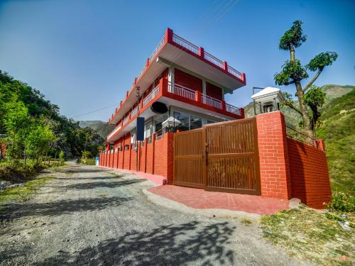 a red brick house with a gate on a road at Sahastradhara RiverResort in Dehradun