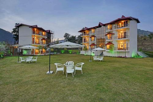 a large building with tables and chairs in front of it at Excel Hotels and Resorts Bhimtal in Bhīm Tāl