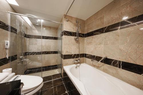 a bathroom with a tub and a toilet and a sink at Best Western Premier Gangnam Hotel in Seoul