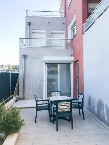 a patio with a table and chairs on a balcony at Hotel et Appartements Reine D'Azur in Roquebrune-Cap-Martin