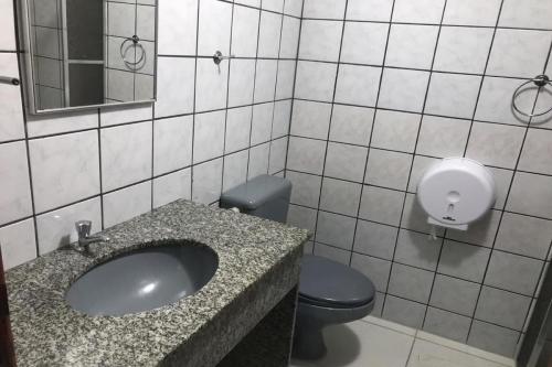 a bathroom with a sink and a toilet and a mirror at Hotel Recanto Do Sol in Porto Seguro