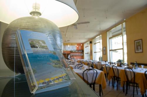 a room with tables and chairs and a large glass jar at Hotel Ambassador in Laigueglia