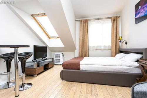 sypialnia z łóżkiem, biurkiem i telewizorem w obiekcie Old Tallinn Apartments w Tallinnie