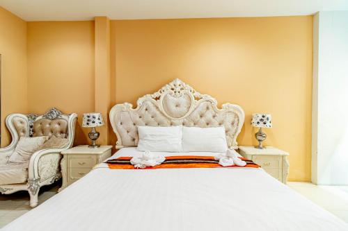 a bedroom with a large white bed and two chairs at The Pool Resort in Bangkok
