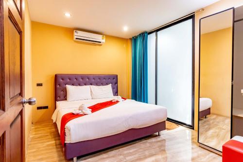 a bedroom with a bed and a large window at The Pool Resort in Bangkok