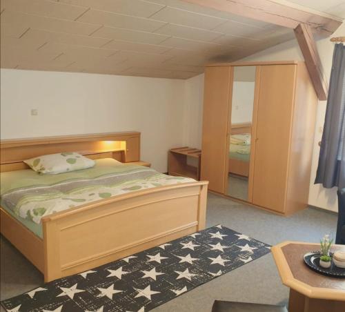 a bedroom with a bed in a room with a table at Landhotel Heidkrug in Munster im Heidekreis