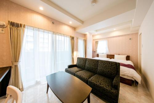 a hotel room with a couch and a bed at VILLA KOSHIDO kotoni in Sapporo