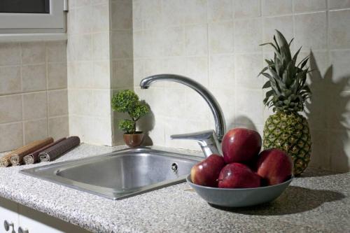 eine Schale Äpfel neben einem Waschbecken in der Unterkunft Two bedroom apartment at Koukaki in Athen
