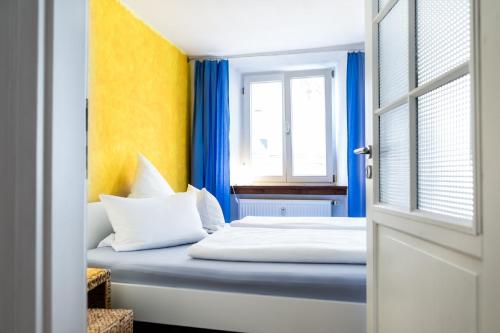 a bedroom with a bed with blue and yellow walls at Ferienwohnung in der Kirchgasse in Landshut