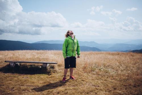 a person standing on top of a hill with a bench at Apartmajsko naselje Ribniško Pohorje in Ribnica na Pohorju