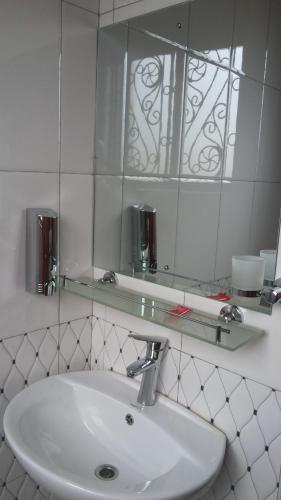 een badkamer met een wastafel en een spiegel bij Egret Pilgrims Inn in Kampala