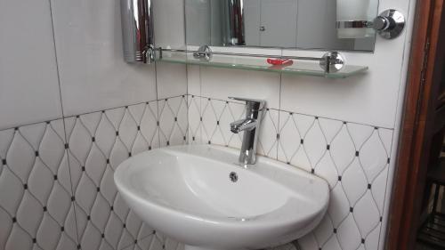 a white sink in a bathroom with a mirror at Egret Pilgrims Inn in Kampala