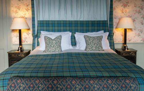 a bedroom with a large bed with two lamps at The Lauderdale at Thirlestane Castle in Lauder