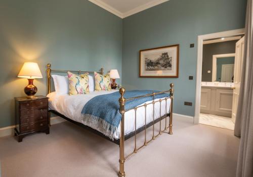 a bedroom with a bed with blue walls at The Maitland at Thirlestane Castle in Lauder
