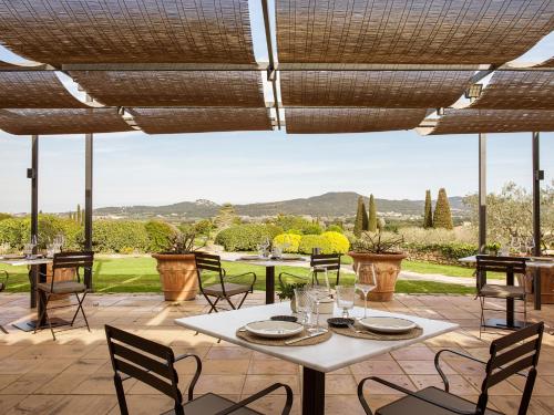 a patio with tables and chairs and a view of the countryside at Mas de Torrent Hotel & Spa, Relais & Châteaux in Torrent