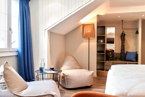 a hotel room with a bed and a chair at The HEY HOTEL in Interlaken