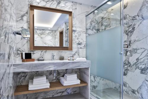 a bathroom with a sink and a mirror at Myconian Korali Relais & Chateaux in Mýkonos City