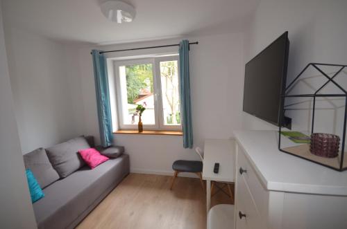 a living room with a couch and a window at Blue Sail Sopot Apartments in Sopot