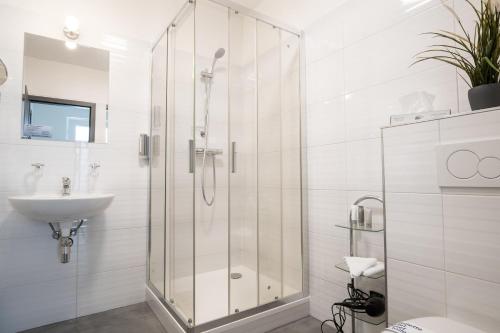 uma casa de banho com um chuveiro e um lavatório. em Fast Lane Hotel em Barweiler