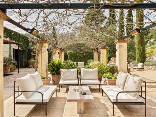 a patio with white chairs and a table at Mas de Torrent Hotel & Spa, Relais & Châteaux in Torrent