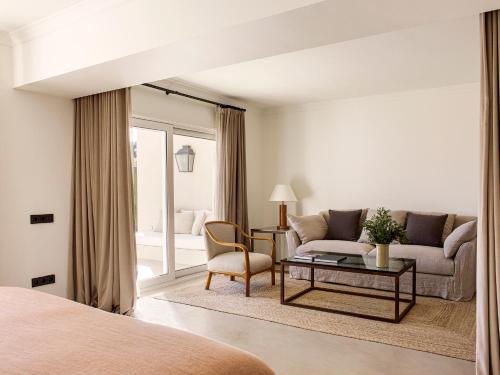 a living room with a couch and a table at Mas de Torrent Hotel & Spa, Relais & Châteaux in Torrent