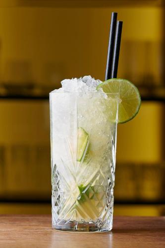a drink with a lime and ice on a table at Aspen Alpine Lifestyle Hotel in Grindelwald