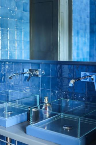a blue tiled bathroom with a sink and a mirror at Podere San Pasquale in Castiglione dʼOrcia