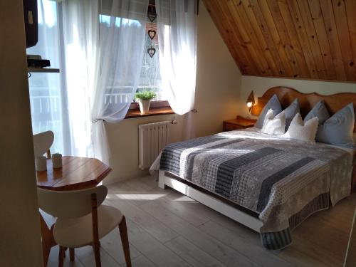 a bedroom with a bed and a desk and a window at Jarek in Pobierowo