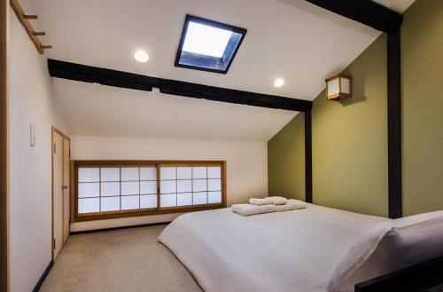 a bedroom with a bed with two towels on it at Shiki Homes ZEN FUYACHO in Kyoto