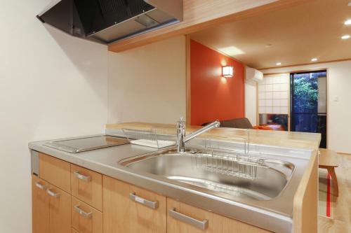 a kitchen with a stainless steel sink in it at Shiki Homes ZEN FUYACHO in Kyoto