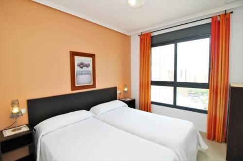 a bedroom with two white beds and a window at Apartamento Gema Gemelos 26 in Benidorm