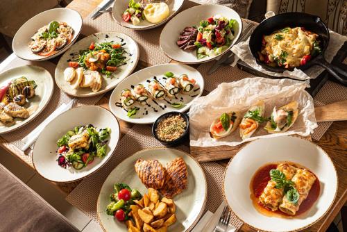 a table with many plates of food on it at HOTEL TRILAGO in Trasaghis