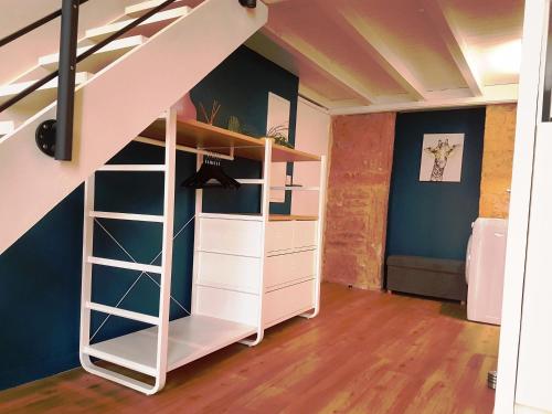 a room with a white book shelf under a stairs at Charmant appartement style Canut Pentes Croix Rousse in Lyon