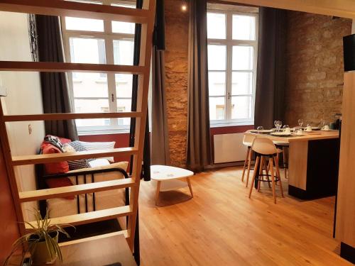 a room with a loft bed and a table with chairs at Cosy appartement, dans les pentes de la Croix Rousse in Lyon