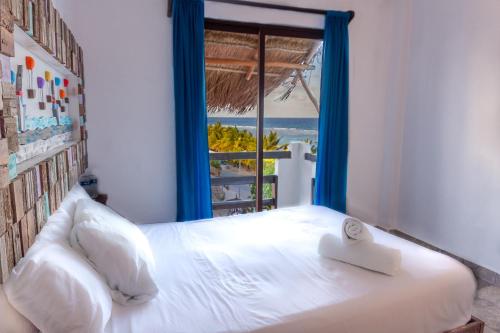 a bedroom with a bed with a view of the ocean at Hotel Blue Reef frente al mar in Mahahual