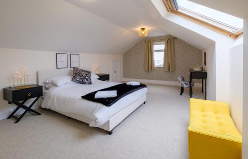 a bedroom with a large bed and a yellow chair at Luxury Living, Stylish Modern Apartment in the Heart of Ryde in Ryde