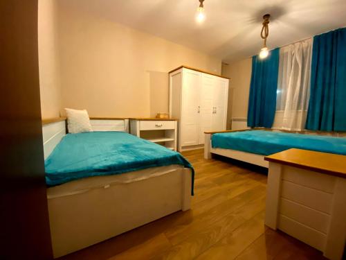 ein kleines Schlafzimmer mit 2 Betten und einem Schreibtisch in der Unterkunft Апартамент РАЙНОВИ in Plewen