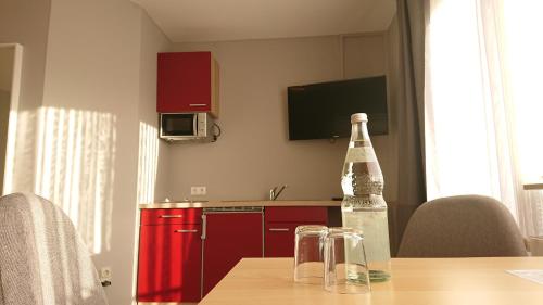 a bottle of wine sitting on a table with a kitchen at Ostseehotel Kappeln by team SchleiFee in Kappeln