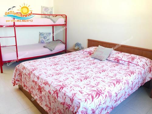 ein Schlafzimmer mit einem Bett und einem Etagenbett in der Unterkunft Bilocale Baia Verde Gallipolitravel in Gallipoli