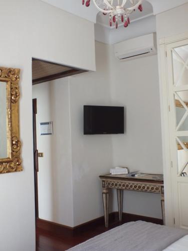 a bedroom with a table and a tv on a wall at Casa Palacio VillaZambra in Ronda