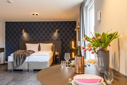 una habitación de hotel con una cama y una mesa con una mesa en MASEVEN München Messe Trudering en Múnich