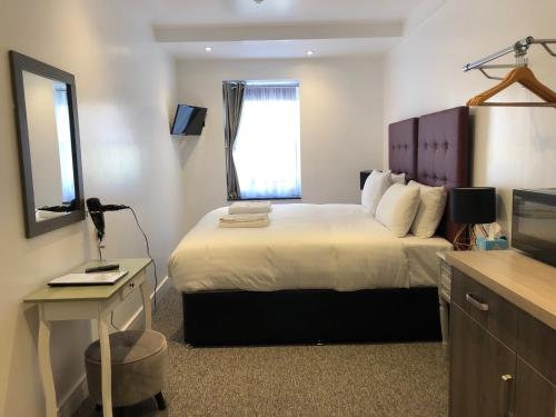 a hotel room with a bed and a television at Kings Hotel in Newmarket
