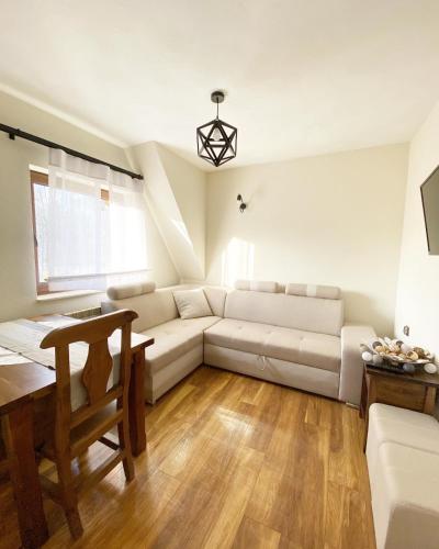 a living room with a white couch and a table at U Maćka in Białka Tatrzanska