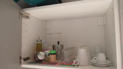 a cupboard with a bunch of items on a shelf at Appartamenti Borghetto San Donato 105 in Bologna