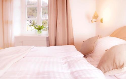 a white bed in a bedroom with a window at Landhaus Halferschenke in Dieblich