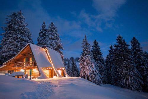 a log cabin in the snow at night at Chalet Alpinka in Cerklje na Gorenjskem